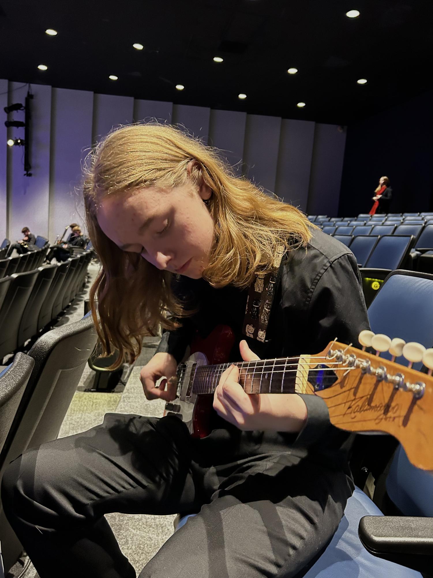 Freshman Clayton Robinson tuning his guitar before Jazz Band's performance